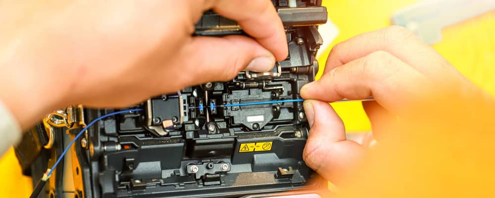 A worker operating a fusion splicing machine