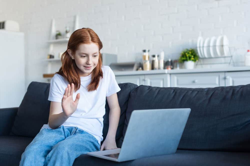 A girl waving hand during a video call