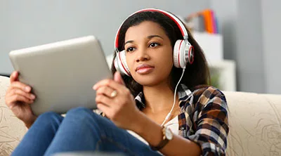 A lady listening to music using iPad headphone