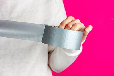 Person unrolling duct tape