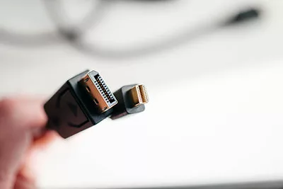 Hand-holding DisplayPort and mini DisplayPort cable