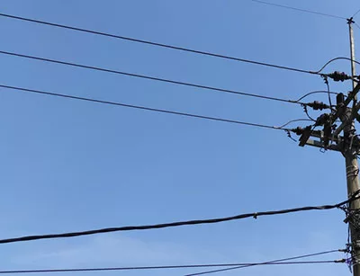 High-voltage power lines in the background of a blue sky