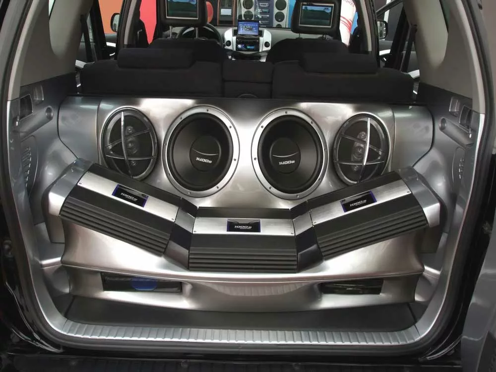 A 4-subwoofer speaker setup in a car’s trunk space.