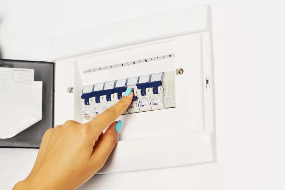 A woman turning off a circuit breaker