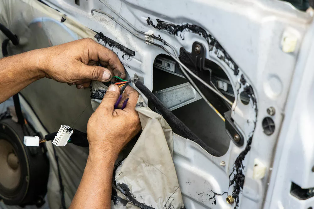Mechanic fixing wiring problem in a car door