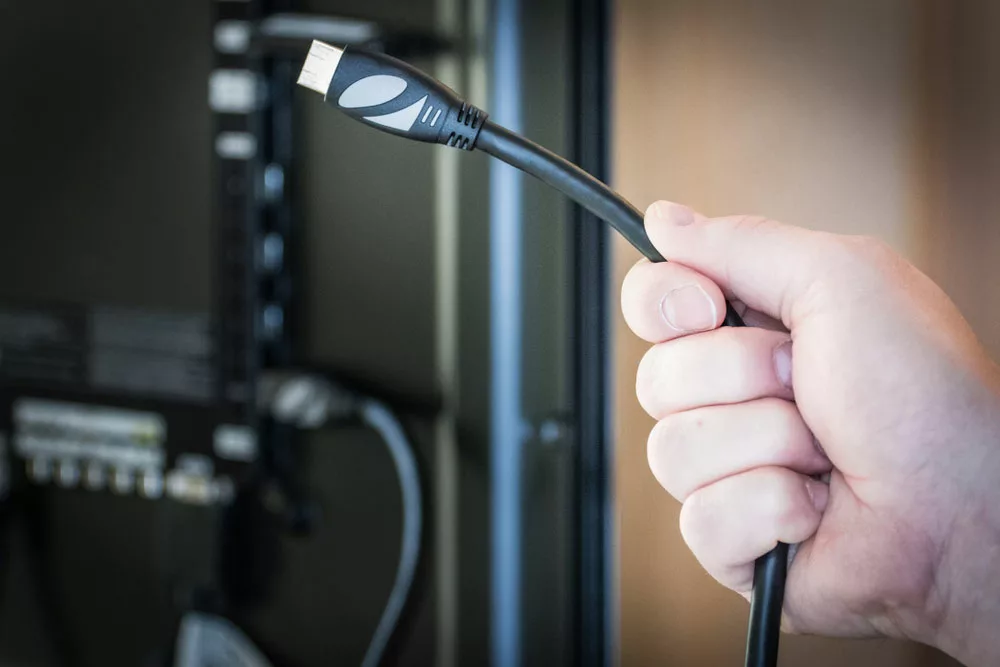 A hand connecting an HDMI Cable