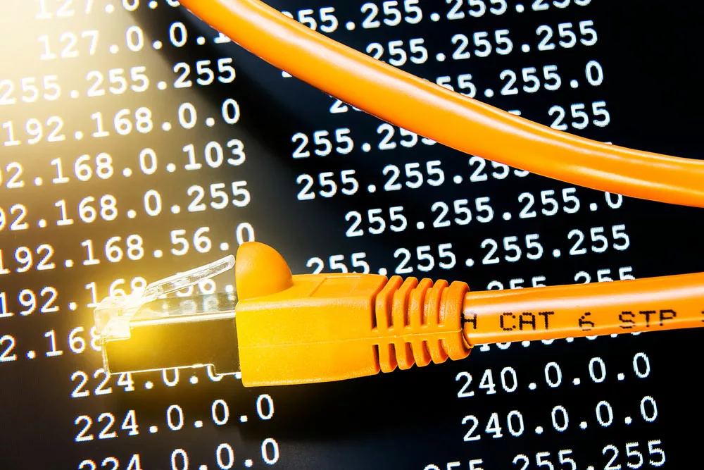 Orange CAT 6 ethernet cable on a routing table background