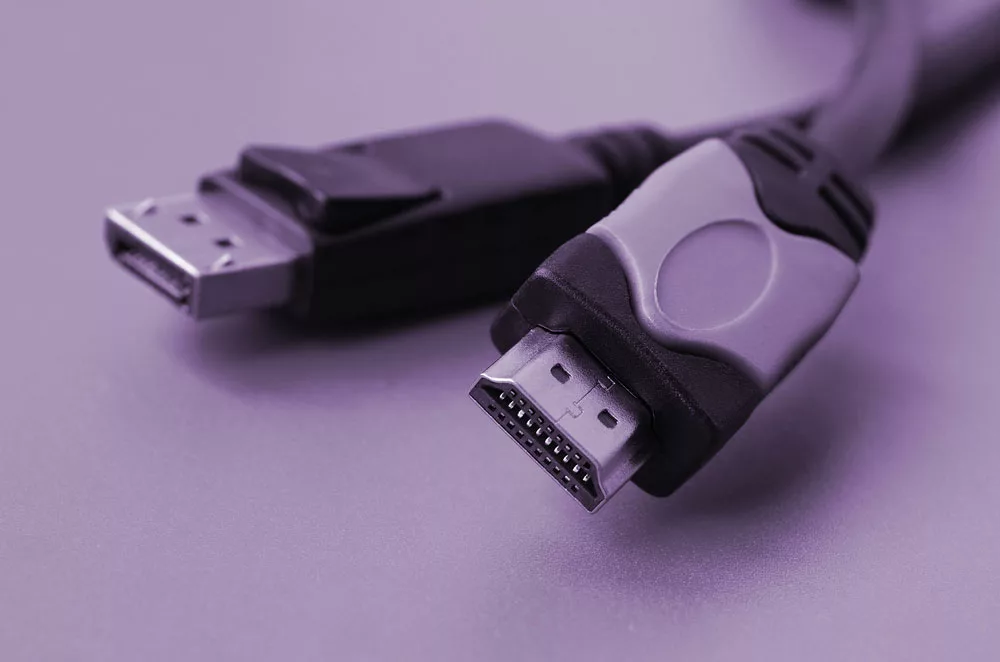 An HDMI and DisplayPort cable on a surface.