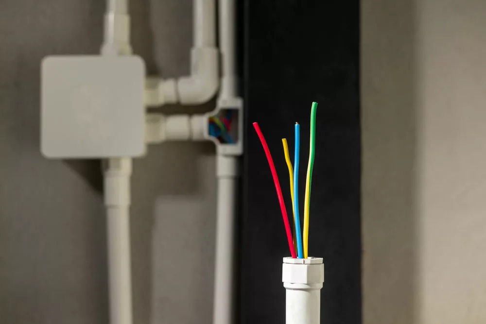 Wires sticking out of a PVC conduit.