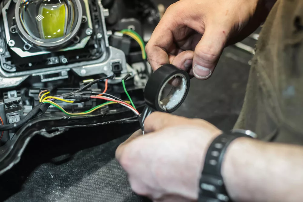 A man fixing wires with electrical tape